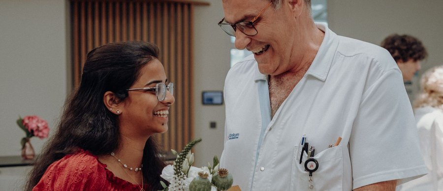 Eine von Kaam-in vermittelte Auszubildende wird von einem Kollegen im Klinikum mit Blumen begrüßt